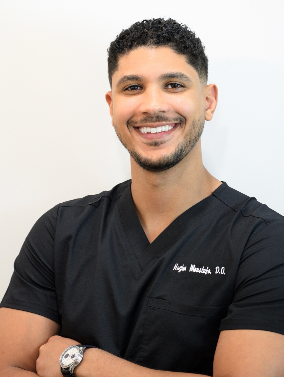 Dr. Hazim Moustafa in clinic scrubs
